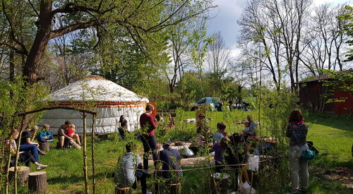 Personen auf einer Wiese vor einer Jurte