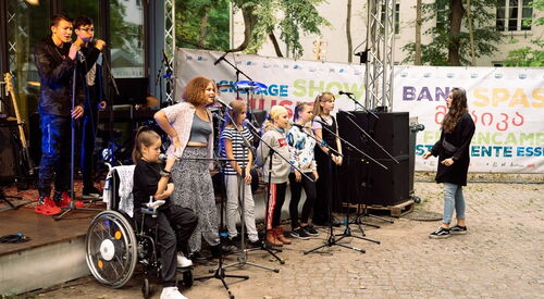 Kinder singen vor einer Bühne