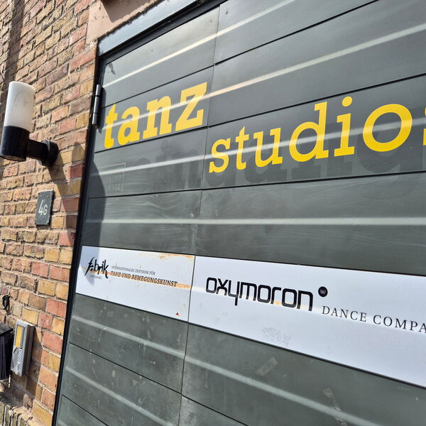 Eine geschlossene Tür. Hausnummer 4G. Auf der Tür steht inn gelber Schrift "Tanzstudios".